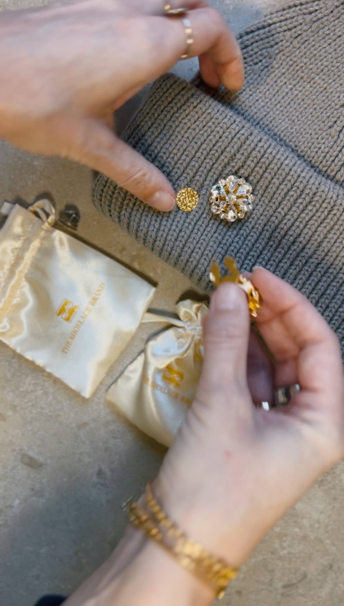 The Shoelace Brand Gold Textured Pin -pinssi nappikorupohjalla