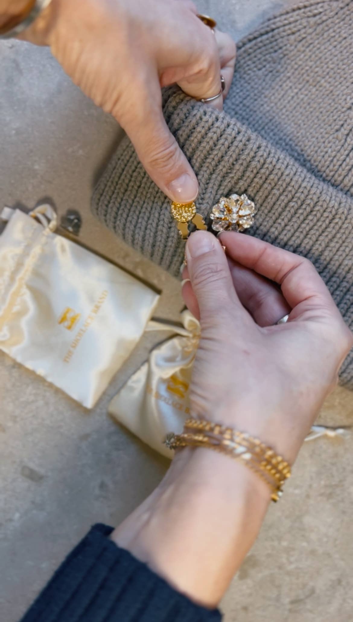 The Shoelace Brand Gold Textured Pin -pinssi nappikorupohjalla